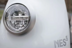 NITO NES 5 elektromos robogó első lámpája és logója közelről, fehér karosszérián.
